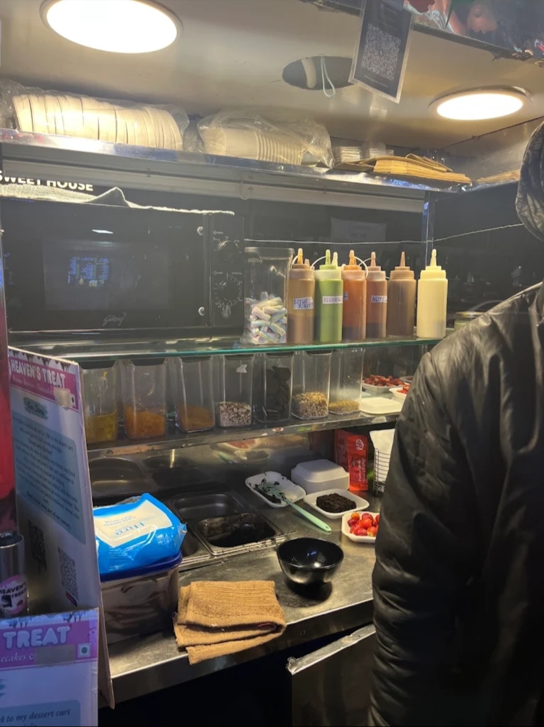 Sauces and toppings lined up inside the cart